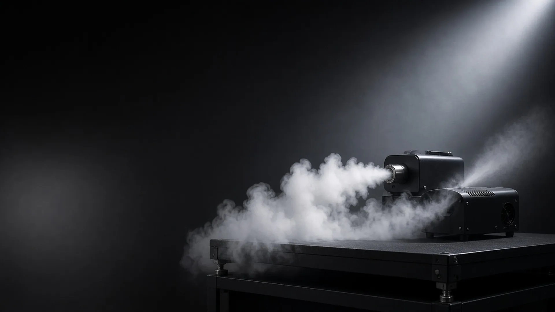 A fog machine and a hazer side by side on a studio riser