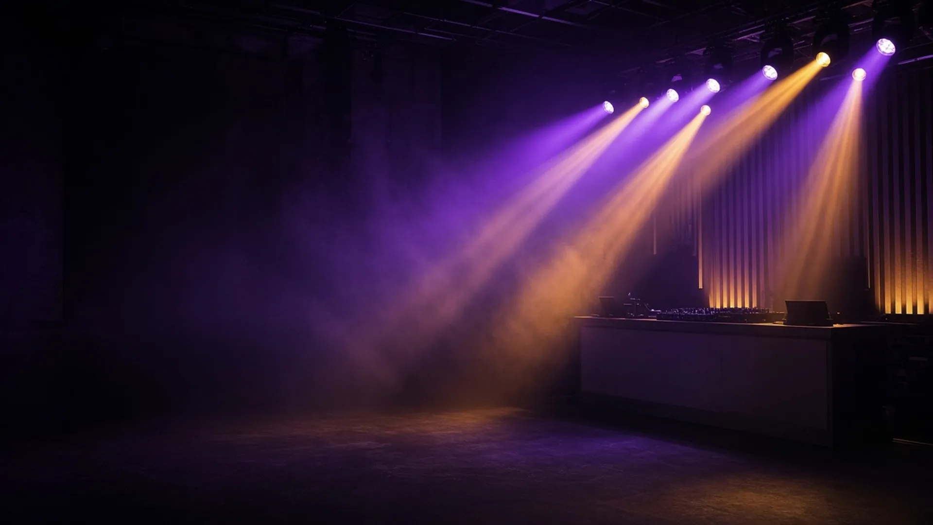 Moving-head light beams fanning through haze above an empty DJ booth