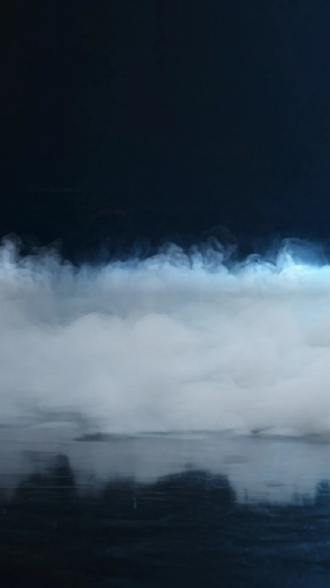 Low white fog hugging a polished stage floor