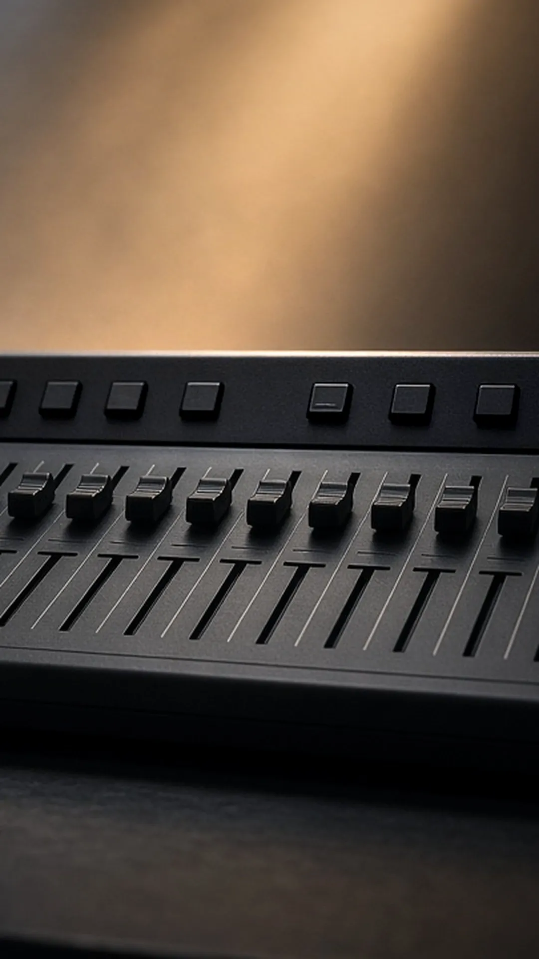 A compact lighting desk with sliders and a coiled five-pin cable beside a fog machine